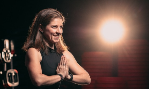 Mirka Philippi v pozici namasté s úsměvem a světlem v pozadí – propojení energie, mindfulness a vedení k vnitřní rovnováze.